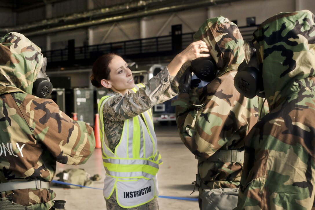 Airman 1st Class Dannielle Garcia, center, checks airmen to see if they are wearing their chemical protective equipment correctly during training at Joint Base McGuire-Dix-Lakehurst, N.J., Oct. 30, 2016. Garcia is assigned to the New Jersey Air National Guard's 108th Wing Emergency Management Office. Air National Guard photo by Tech. Sgt. Matt Hecht