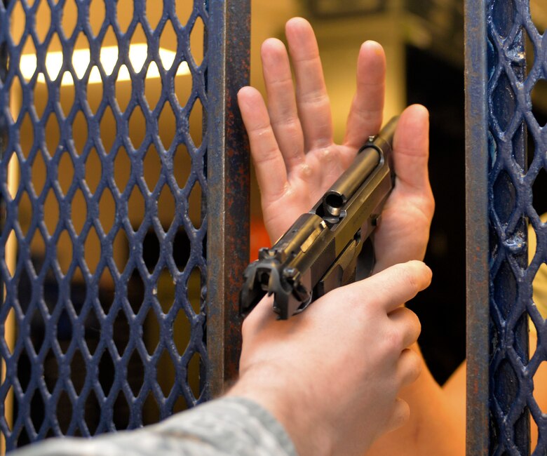 Airman 1st Class John Stumpf, an armorer assigned to the 28th Security Forces Squadron, provides an M9 pistol to Senior Airman Devon Malone, a response force leader assigned to the 28th SFS, in the armory at Ellsworth AFB, S.D., Oct. 25, 2016. Airmen assigned to the 28th SFS on regular day-to day operations are provided with weapons, ammunition, and less-than-lethal equipment such as tasers, radar and radios to assist with protecting the base. (U.S. Air Force photo by Airman 1st Class Donald Knechtel)