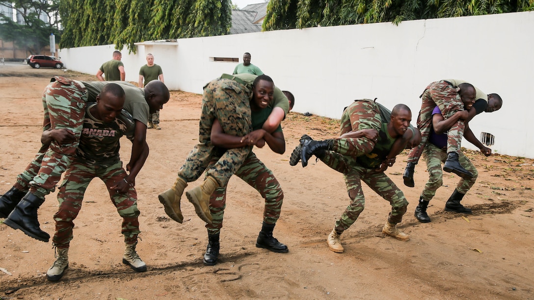 Sailors with the Benin Navy conduct buddy squats during a physical fitness session with U.S. Marines at Benin Naval Forces Headquarters, Cotonou, Benin, October 25, 2016. The U.S. Marine Corps theater security cooperation team with Special Purpose Marine Air-Ground Task Force Crisis Response-Africa spent two weeks teaching an NCO development and maintenance management course during their time training with the Benin Navy.  