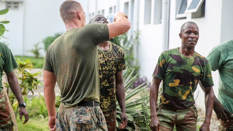 Staff Sgt. Michael Reinert, a training chief with Special Purpose Marine Air-Ground Task Force Crisis Response-Africa, shares some water with a sailor from the Benin Navy following a physical fitness session at Benin Naval Forces Headquarters, Cotonou, Benin, October 25, 2016. The U.S. Marine Corps theater security cooperation team with Special Purpose Marine Air-Ground Task Force Crisis Response-Africa spent two weeks teaching an NCO development and maintenance management course during their time training with the Benin Navy.  