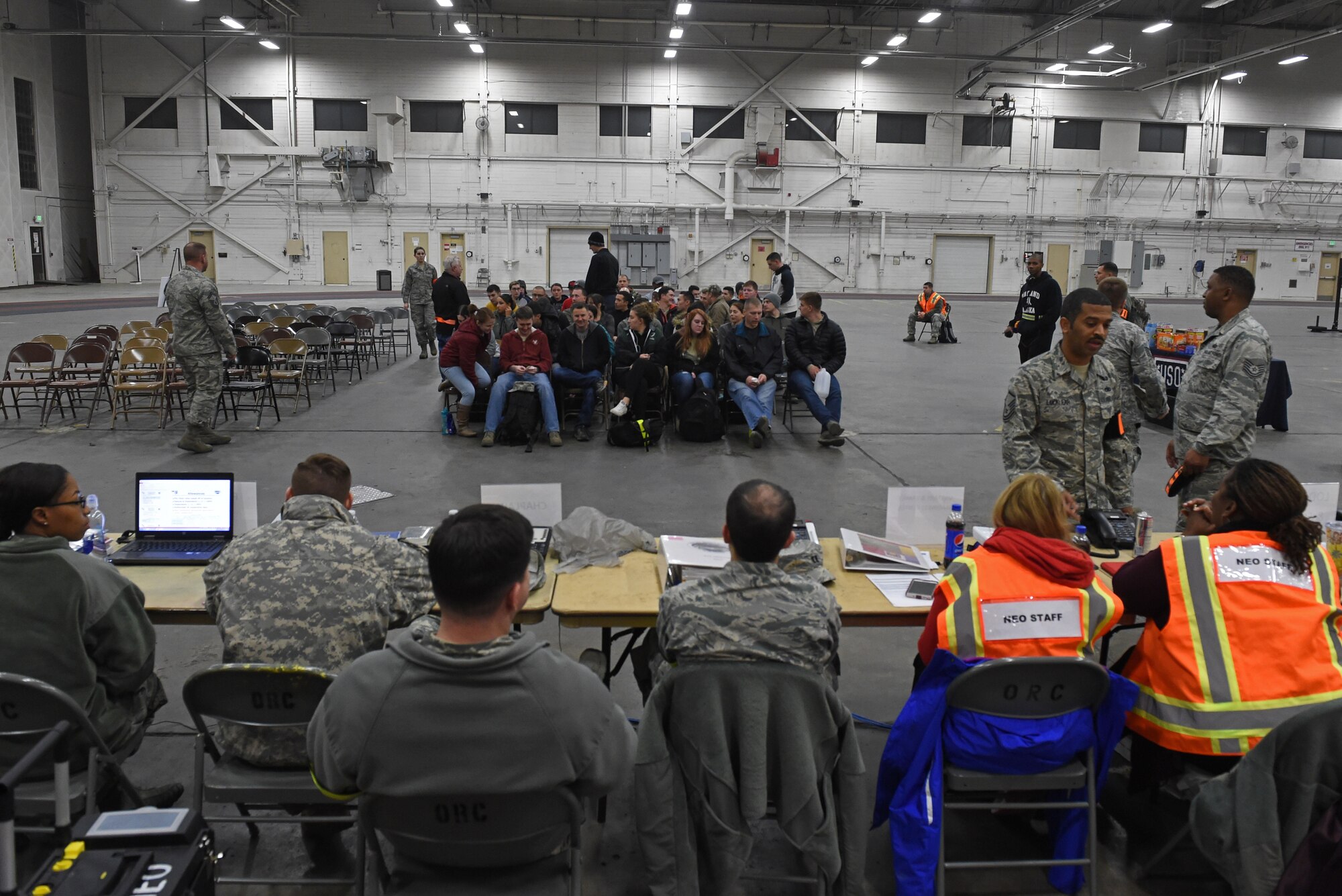 Participants of a noncombatant evacuation operation exercise walk through an in-processing line at Hangar 5, Joint Base Elmendorf-Richardson, Alaska, Nov. 3, 2016. The scenario was part of exercise Polar Force 17-1, which is designed to help validate and evaluate the wings' ability to integrate, mobilize, and prepare assigned personnel, aircraft and equipment for a wartime mission. 