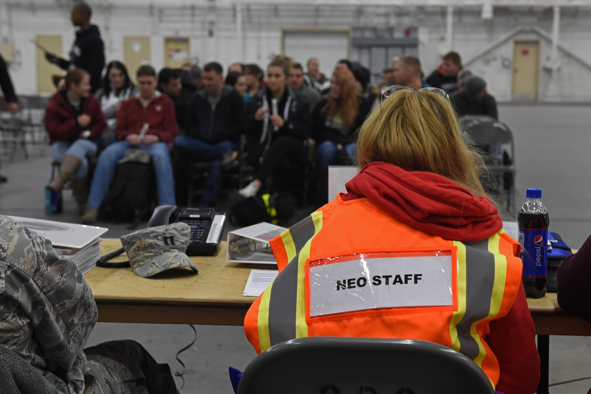 Participants of a noncombatant evacuation operation exercise walk through an in-processing line at Hangar 5, Joint Base Elmendorf-Richardson, Alaska, Nov. 3, 2016. The scenario was part of exercise Polar Force 17-1, which is designed to help validate and evaluate the wings' ability to integrate, mobilize, and prepare assigned personnel, aircraft and equipment for a wartime mission. 