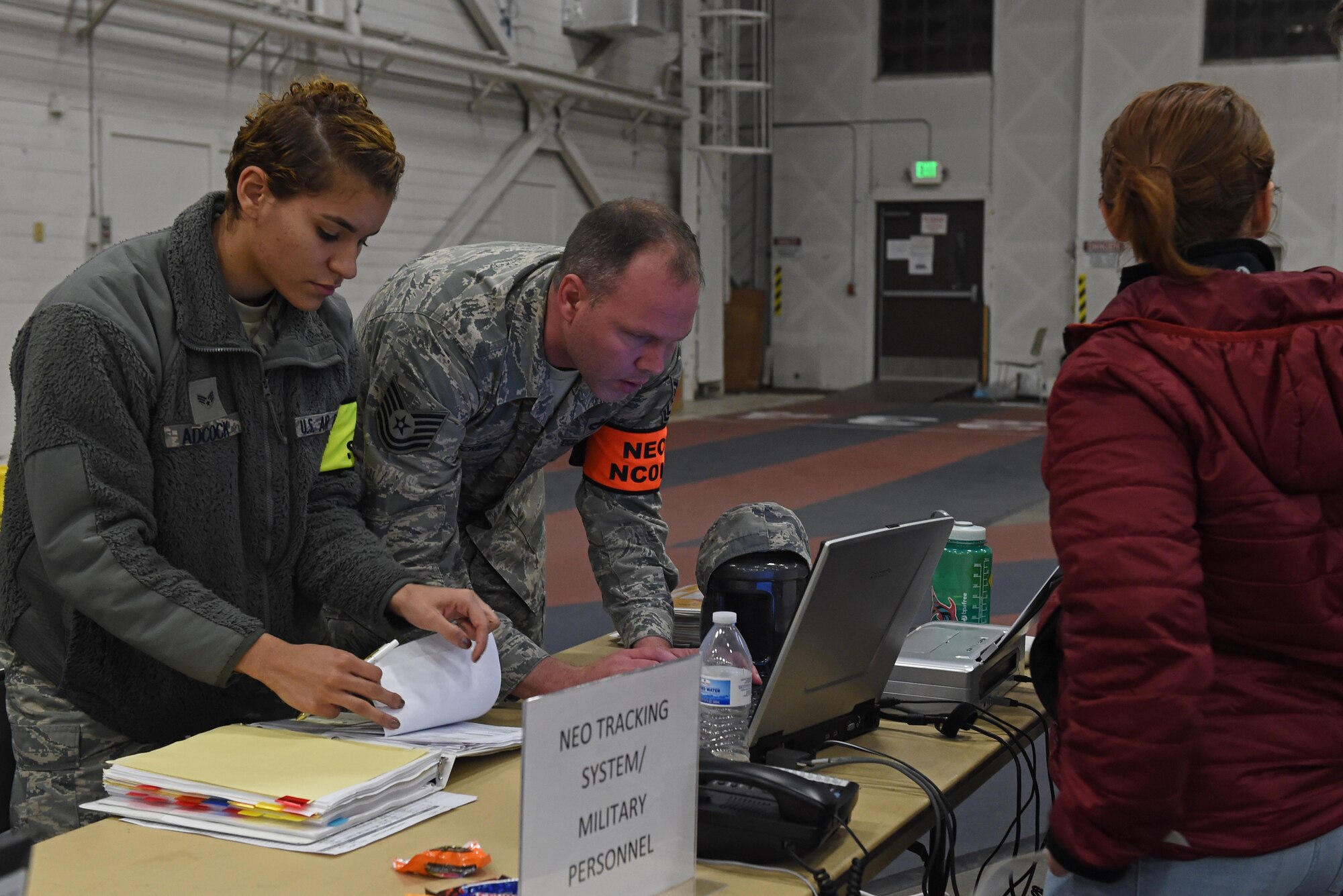 Participants of a noncombatant evacuation operation exercise walk through an in-processing line at Hangar 5, Joint Base Elmendorf-Richardson, Alaska, Nov. 3, 2016. The scenario was part of exercise Polar Force 17-1, which is designed to help validate and evaluate the wings' ability to integrate, mobilize, and prepare assigned personnel, aircraft and equipment for a wartime mission. 