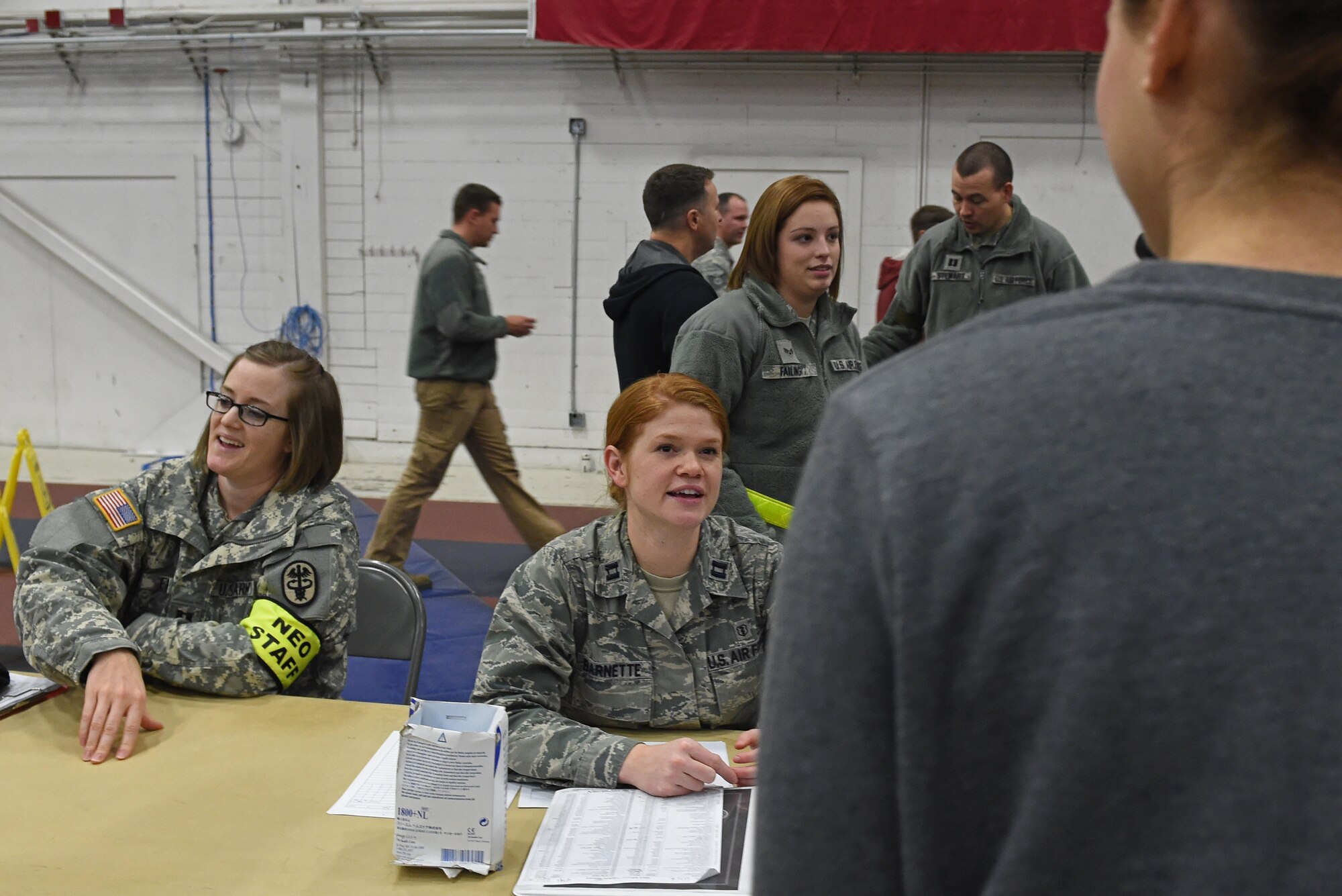 Participants of a noncombatant evacuation operation exercise walk through an in-processing line at Hangar 5, Joint Base Elmendorf-Richardson, Alaska, Nov. 3, 2016. The scenario was part of exercise Polar Force 17-1, which is designed to help validate and evaluate the wings' ability to integrate, mobilize, and prepare assigned personnel, aircraft and equipment for a wartime mission. 