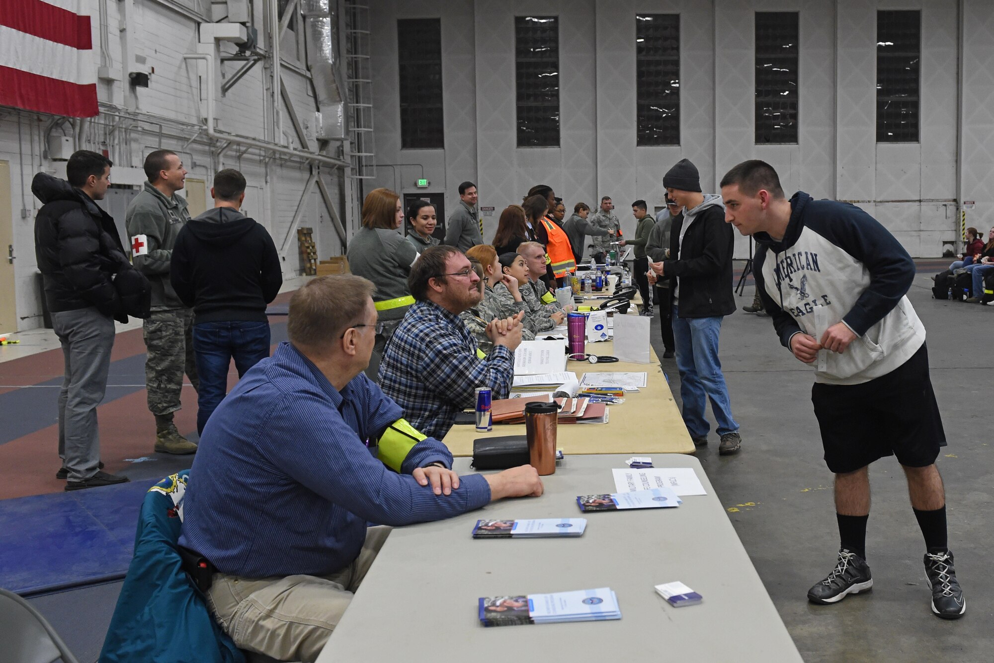 Participants of a noncombatant evacuation operation exercise walk through an in-processing line at Hangar 5, Joint Base Elmendorf-Richardson, Alaska, Nov. 3, 2016. The scenario was part of exercise Polar Force 17-1, which is designed to help validate and evaluate the wings' ability to integrate, mobilize, and prepare assigned personnel, aircraft and equipment for a wartime mission. 