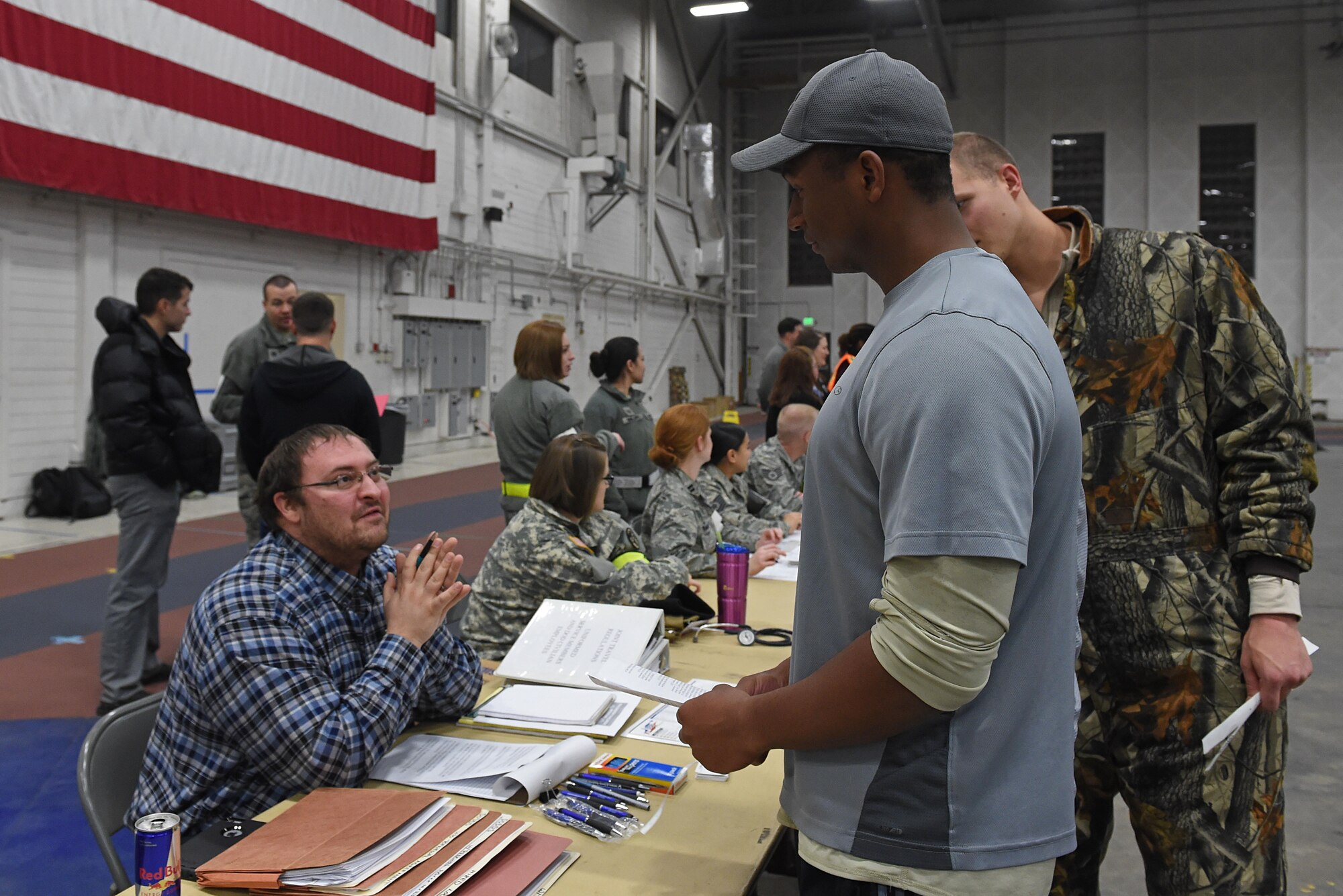 Participants of a noncombatant evacuation operation exercise walk through an in-processing line at Hangar 5, Joint Base Elmendorf-Richardson, Alaska, Nov. 3, 2016. The scenario was part of exercise Polar Force 17-1, which is designed to help validate and evaluate the wings' ability to integrate, mobilize, and prepare assigned personnel, aircraft and equipment for a wartime mission. 