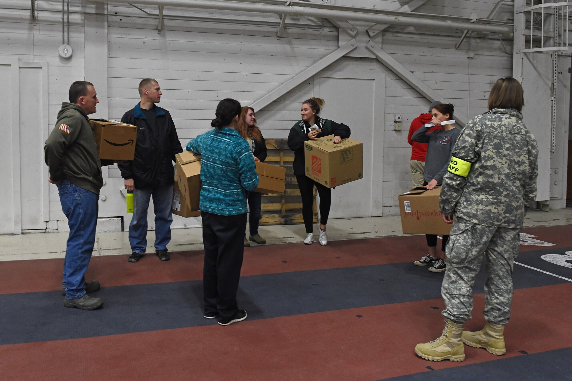 Participants of a noncombatant evacuation operation exercise walk through an in-processing line at Hangar 5, Joint Base Elmendorf-Richardson, Alaska, Nov. 3, 2016. The scenario was part of exercise Polar Force 17-1, which is designed to help validate and evaluate the wings' ability to integrate, mobilize, and prepare assigned personnel, aircraft and equipment for a wartime mission. 
