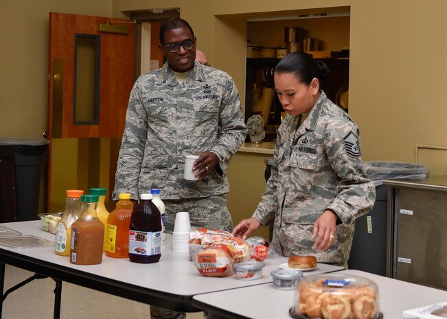 Master Sgt. William Anderson, left, 628th Air Base Wing Chaplain Corps superintendent, and Master Sgt. Irene Williams, right, Air Mobility Command Chaplain assistant functional manager, fill their plates during a breakfast with Joint Base Charleston chapel staff here, Nov. 3, 2016. Chaplain (Col.) Tims, AMC command chaplain, met with chapel staff and participated in a promotion ceremony while visiting JB Charleston Nov. 2 through Nov. 6.