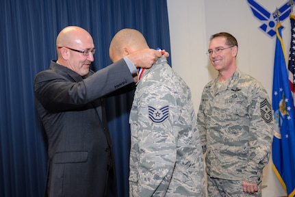 An ISR Airman receives a Larson Award medal from Lee Anthony, executive council representative, Freedom Through Viligance Association, Nov. 2 at 25th Air Force Headquarters, as Command Chief Master Sgt. Roger Towberman observes. (U.S. Air Force photo/William B. Belcher)