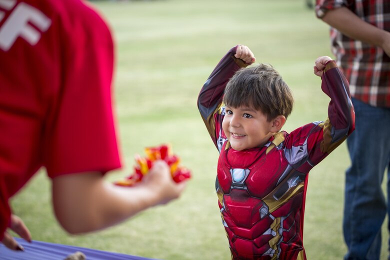 Aaron Espinoza, 3, son of Logan Espinoza, shows off his muscles while trick-or-treating at the Jack-O-Lantern Jubilee hosted by Marine Corps Community Services at Del Valle Field aboard the Marine Corps Air Ground Combat Center, Twentynine Palms, Calif., Oct. 28, 2016. (Official Marine Corps photo by Cpl. Levi Schultz/Released)