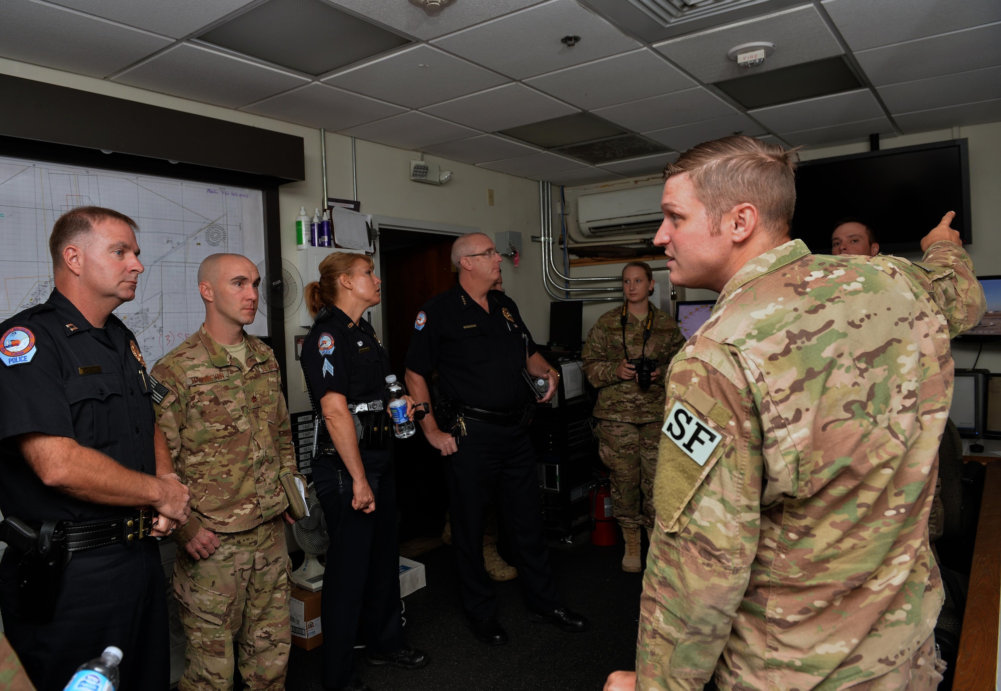 Staff Sgt. Benjamin McCorkel, right, a desk sergeant with the 1st Special Operations Security Forces Squadron, briefs Fort Walton Beach police officers on base defense operations control center procedures during a tour at Hurlburt Field, Fla., Nov. 1, 2016. The FWB officers visited the BDOC center to learn how base security systems operate and keep Hurlburt secure. (U.S. Air Force photo by Senior Airman Andrea Posey)