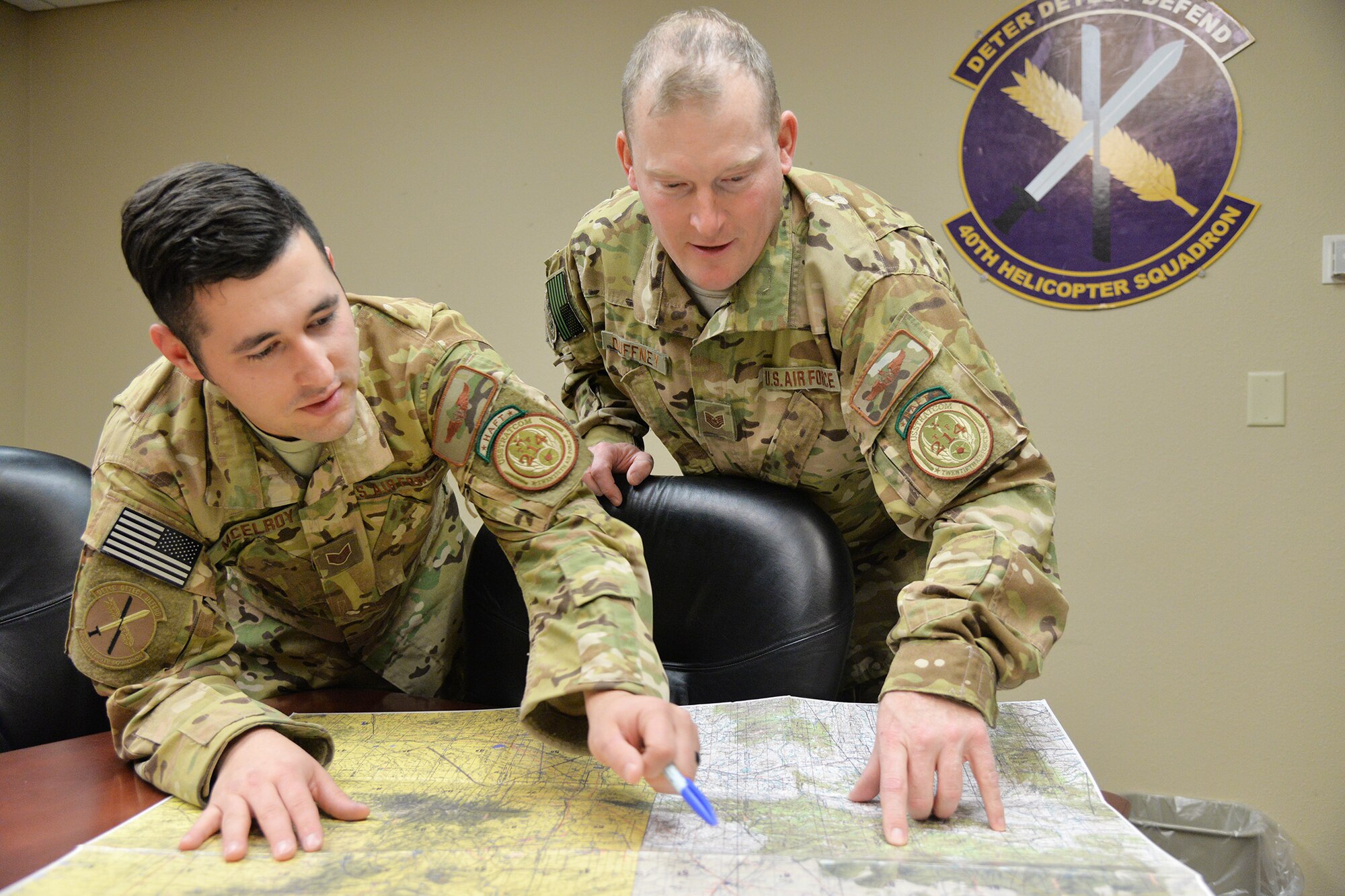 Staff Sgt. Eric McElroy, left, and Tech. Sgt. Michael Duffney, 40th Helicopter Squadron flight engineers, review a land map Nov. 2, 2016, at Malmstrom Air Force Base, Mont. Flight engineers assist pilots in flying the aircraft and ensuring the helicopter has enough fuel and weight to safely and successfully execute a mission. (U.S. Air Force photo/Airman 1st Class Daniel Brosam)