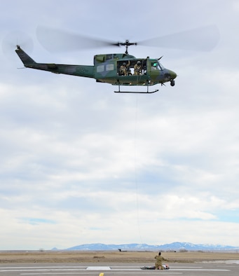 Members of the 40th Helicopter Squadron train using a Stokes litter to raise a simulated injured patient into the aircraft Feb. 2, 2016, at Malmstrom Air Force Base, Mont. The 40th HS trains for search and rescue missions in addition to the security mission they support here at the 341st Missile Wing. (U.S. Air Force photo/Airman Daniel Brosam)