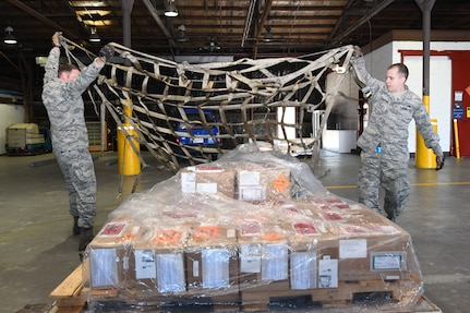 U.S. Air Force Staff Sgt. Richard Allen, 731st Air Mobility Squadron special planning supervisor, and Airman 1st Class Kevin Johnston, 731st AMS special planning technician, toss a securing net over an ammunitions shipping build during routine shipping operations at Osan Air Base, Republic of Korea, Nov. 2, 2016. The special handlers provide storage and shipping requirements for critical military items across the Korean Peninsula. 