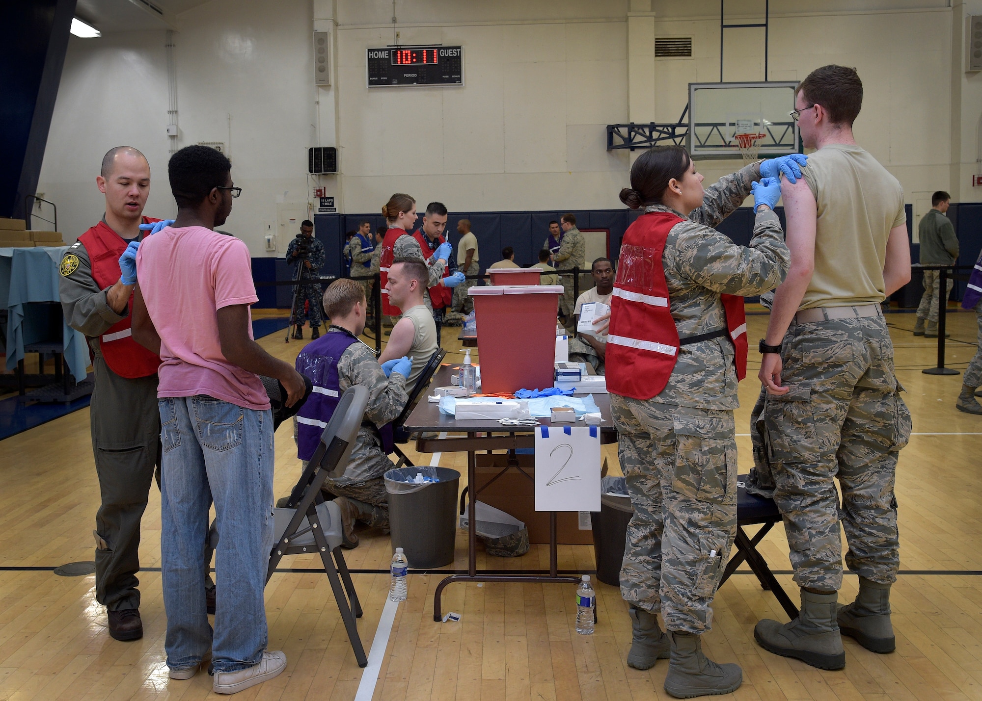 U.S. Air Force and Navy medical personnel administer the flu vaccine during a point of distribution, at Misawa Air Base, Japan, Nov. 3, 2016. Within the first hour, more than 300 individuals came through the flu POD. On average, each individual took 50 seconds to complete the process of prescreening questions, receiving the vaccination and the administration process. All members eligible to receive health care at the 35th MDG acquired their vaccine through the POD. (U.S. Air Force photo by Senior Airman Deana Heitzman)