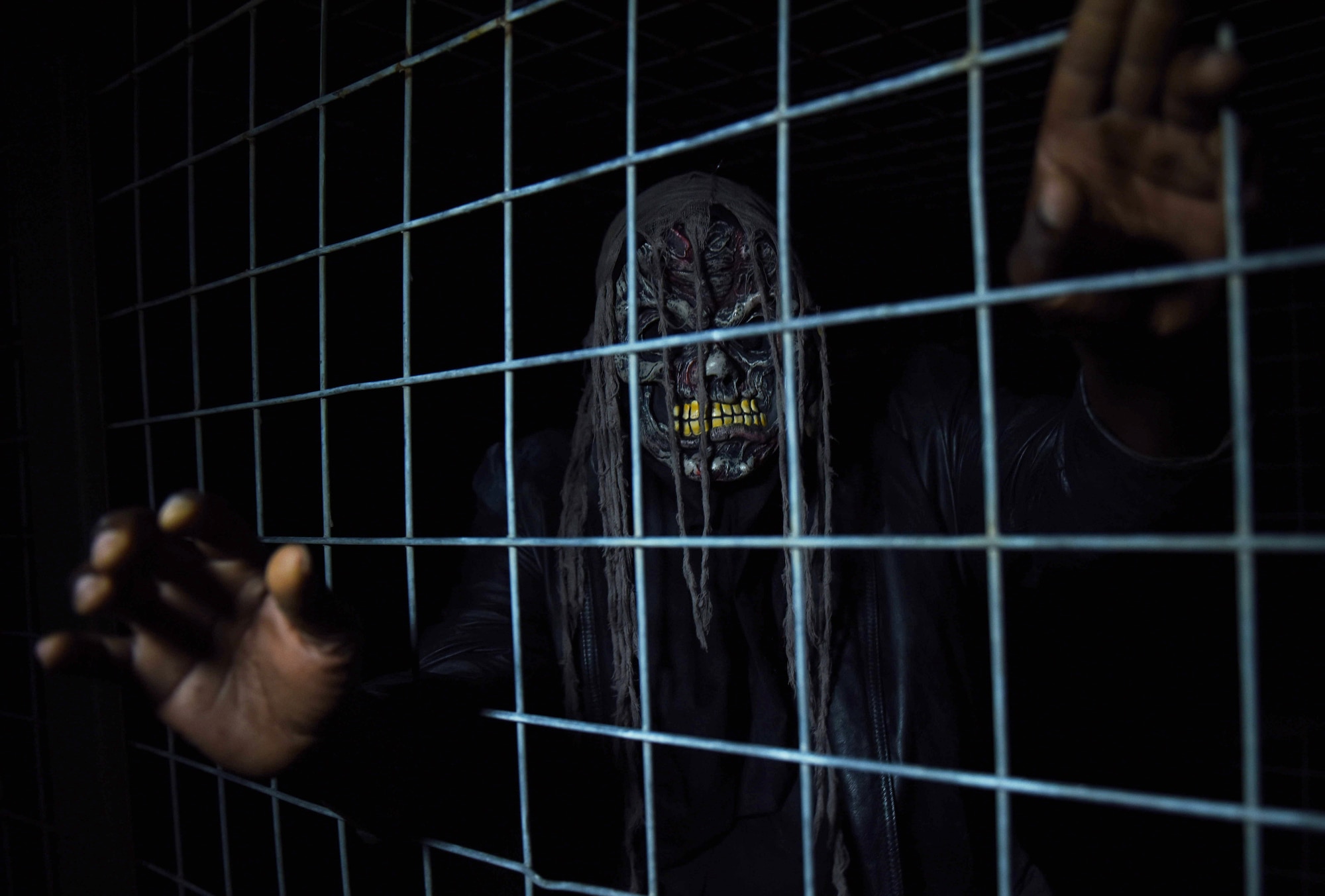 Gregory Robinson, Haunted Asylum volunteer actor, reaches through a cage during the 30th Security Force Squadron’s third annual Haunted Asylum, Oct. 31, 2016, Vandenberg Air Force Base, Calif. Originally a mostly local attraction, Tech. Sgt. Thomas Martin, 30th SFS flight sergeant, has built a sterling reputation for the haunted house -- which was voted one of the best Halloween attractions on the entire Central Coast by users on the websites Yelp and TripAdvisor. (U.S. Air Force Photo by Senior Airman Kyla Gifford/Released)