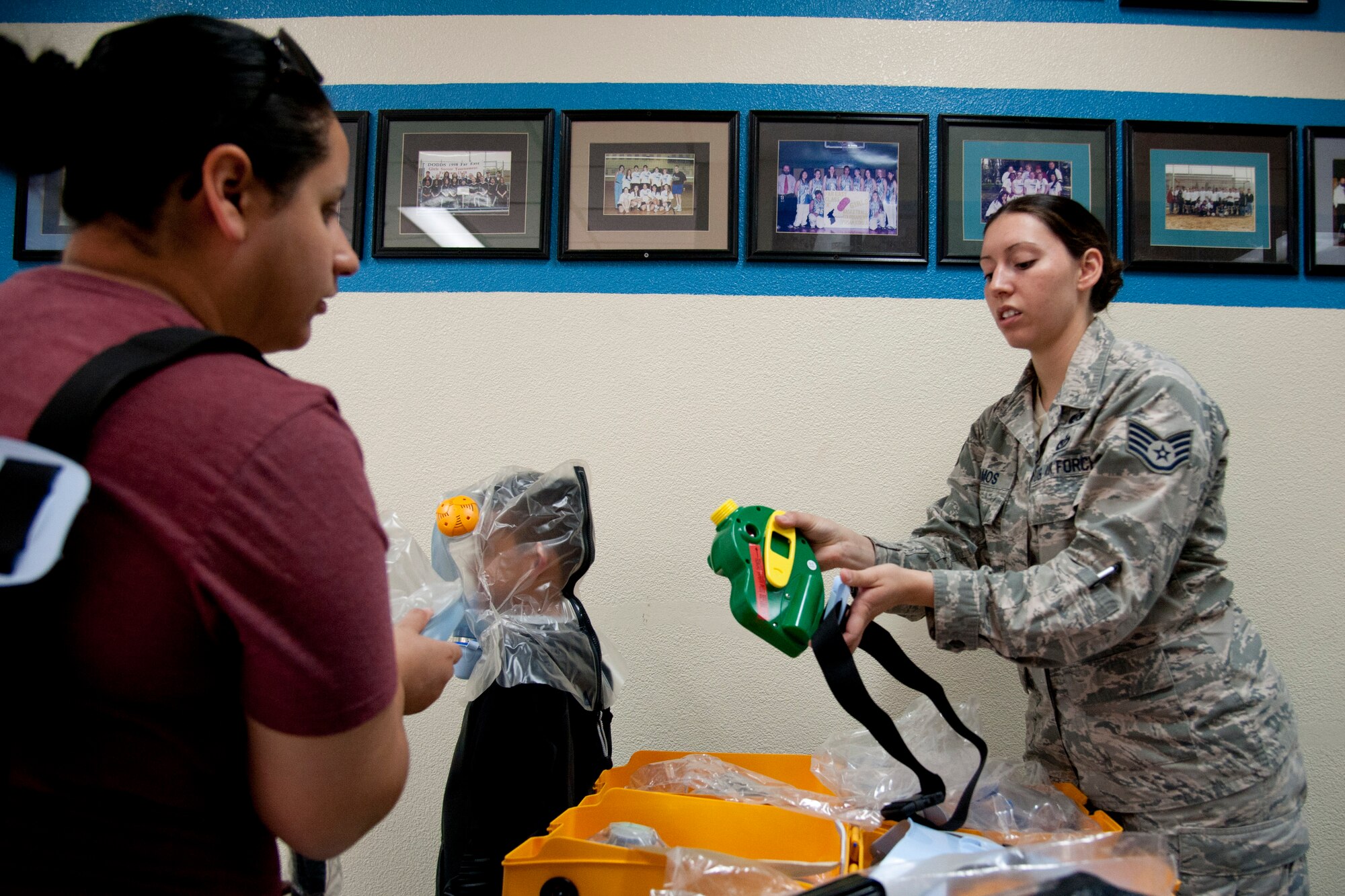 U.S. Air Force Staff Sgt. Kristina Ramos, 51st Civil Engineer Squadron NCO in charge of emergency management training, shows Stephanie Shufelt and her son Damian how to use an infant and child nuclear, biological and chemical positive-pressure protective system during exercise Courageous Channel 2016 at Osan Air Base, Republic of Korea, Oct. 29, 2016. During the exercise, families had a chance to wear and learn about the protective system that could protect them from nuclear, biological and chemical contaminates. (U.S. Air Force photo by Staff Sgt. Jonathan Steffen)  