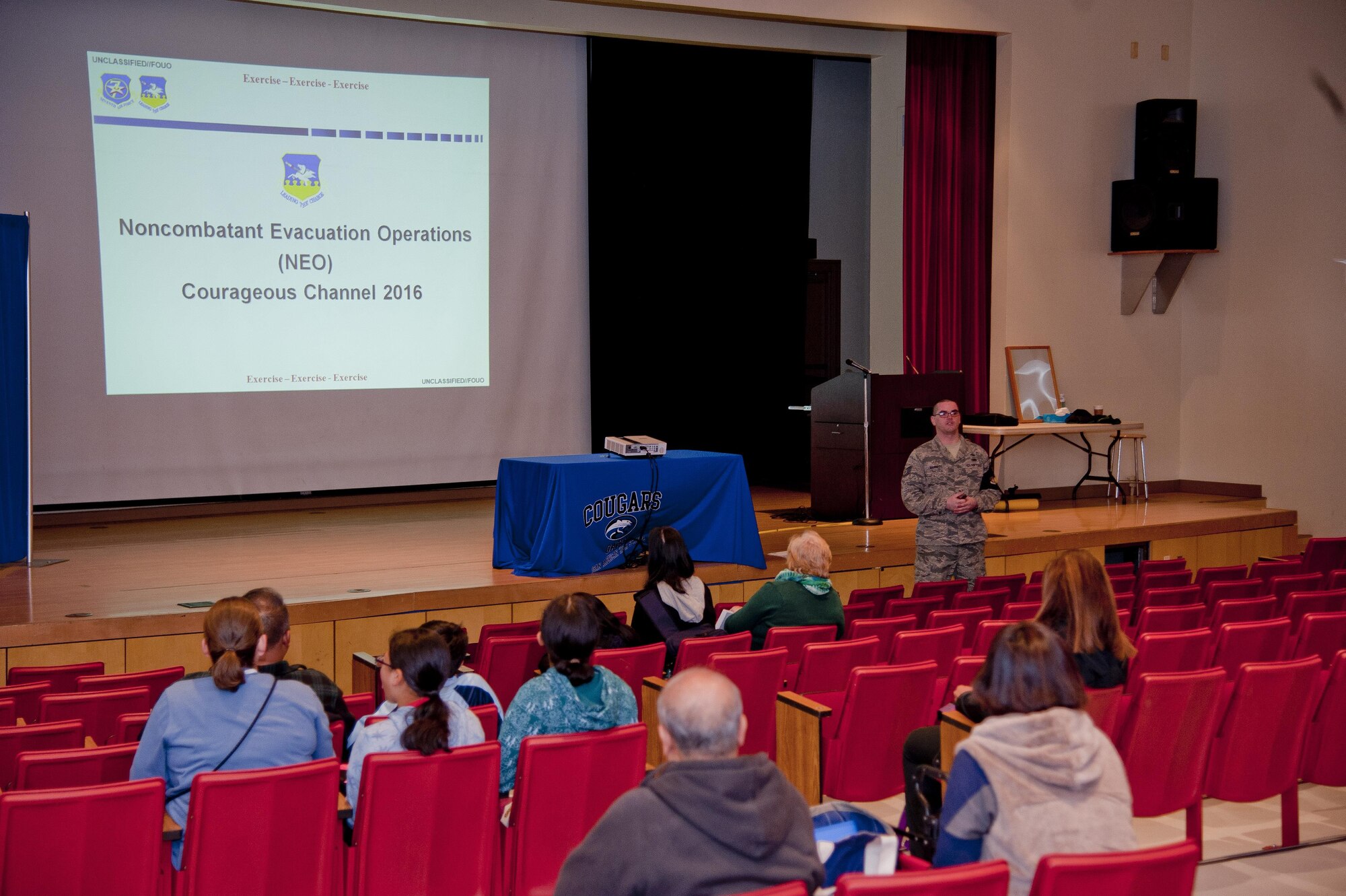 U.S. Air Force Tech. Sgt. Seth Barrett, 51st Logistics Readiness Squadron NCO in charge of material control, gives a Non-combatant Evacuation Operations reception briefing during exercise Courageous Channel 2016 at Osan Air Base, Republic of Korea, Oct. 29, 2016. The NEO reception briefing gives the non-combatant families an overview of the process and timeline if they were to be evacuated. (U.S. Air Force photo by Staff Sgt. Jonathan Steffen)