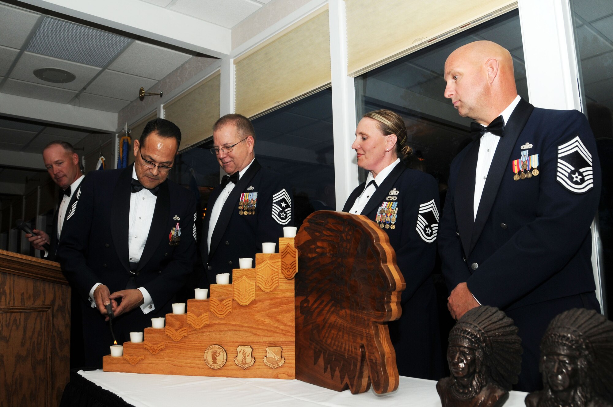 Montana Air National Guard State Command Chief Master Sgt. Timothy Zumbrun narrates as Chief Master Sgt. Osvaldo Mendez lights the first candle representing the United States Air Force enlisted force structure during the Montana Air National Guard Chief Induction Ceremony held at the Meadowlark Country Club in Great Falls, Mont., Sept. 30, 2016. 120th Airlift Wing Command Chief Master Sgt. Steven Lynch assisted Mendez as Chief Master Sgts. Teresa Parker and John Weber waited to participate in the ceremony. (U.S. Air National Guard photo by Senior Master Sgt. Eric Peterson)