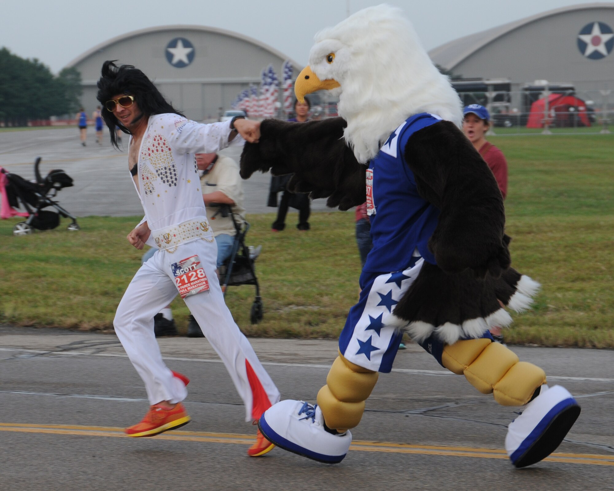 Tailwind, the U. S. Air Force Marathon mascot, encourages Elvis by giving him a fist bump at the start of the race at Wright-Patterson Air Force Base, Ohio, Sept. 17, 2016. The U. S. Air Force Marathon introduced Tailwind, an eagle in running shoes, this year in celebration of the 20th anniversary.  (U.S. Air National Guard photo/Staff Sgt. Lindsey Soulsby)