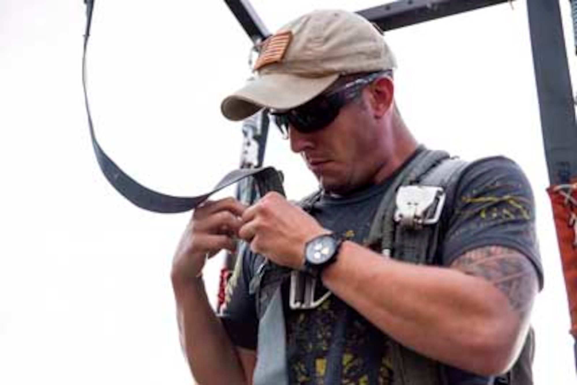 Senior Airman Mitch Bortchert, a 154th Training Squadron loadmaster, tightens the straps to a hanging harness during water survival and emergency training Oct. 1, 2016, at Lake Ouachita, Arkansas. The two-day training event consisted of aircrew flight equipment training, water survival training and self-aid buddy care. (U.S. Air National Guard photo by Tech. Sgt. Jessica Condit)