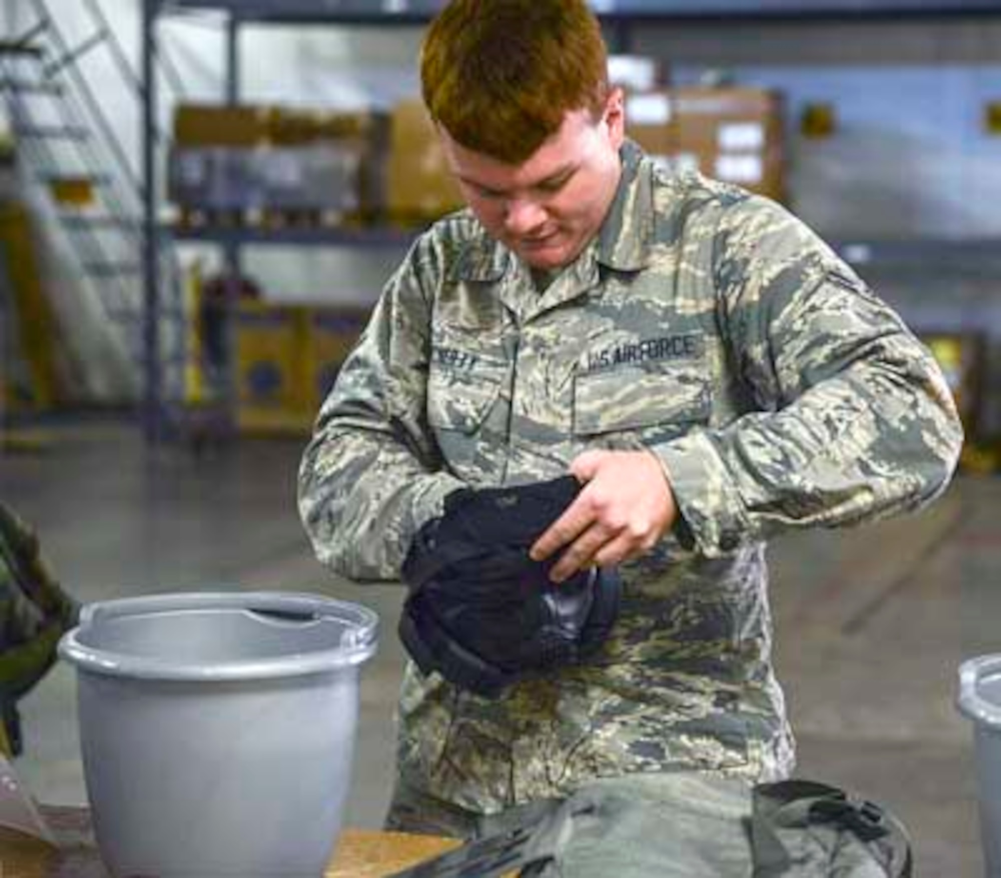 Airman First Class Cameron McNulty, a 189th Maintenance Group aircraft mechanic, cleans out his protective mask after completing CBRN training. During the training, Airmen practiced donning MOPP gear, being timed as they did so in order to replicate the amount of time they would have in the event of an attack. (U.S. Air National Guard photo by Tech. Sgt. Jessica Condit)