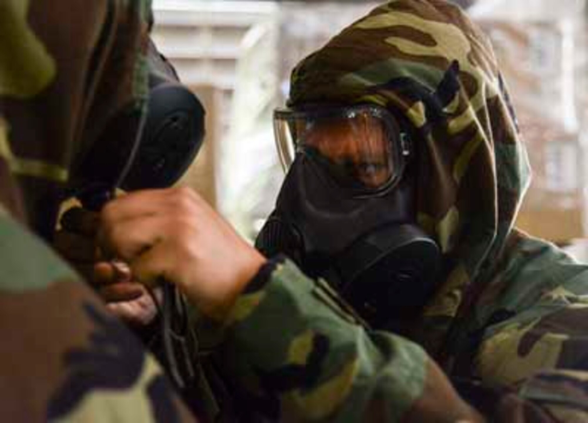 Airmen from the 189th Airlift Wing assist each other in checking for leaks in the protective mask used during a chemical, biological, radiological or nuclear attack Oct. 6, 2016, at Little Rock Air Force Base. The masks along with charcoal-lined protective clothing, provide a layer of protection against enemy CBRN attacks. (U.S. Air National Guard photo by Tech. Sgt. Jessica Condit)