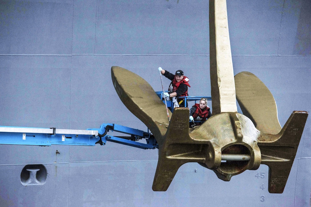 Navy Seamen Casey Dievendorf and Felicity Maxfield paint the starboard anchor aboard the aircraft carrier USS John C. Stennis in Bremerton, Wash., Nov. 1, 2016. The gold anchors are a symbol of the Retention Excellence Award for sustaining superior levels of military retention. The aircraft carrier is conducting a scheduled maintenance availability at Naval Base Kitsap-Bremerton. Navy photo by Petty Officer 3rd Class Dakota Rayburn