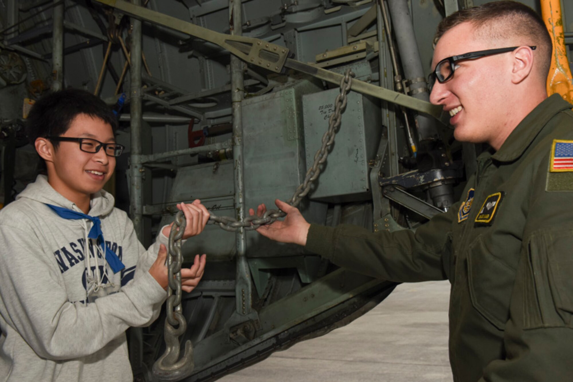 Senior Airman Alexander Lauher, 36th Airlift Squadron C-130 Hercules loadmaster, shows loading equipment to an attendee during the Youth international Exchange Fair at Yokota Air Base, Japan, Oct. 29, 2016. The fair hosted by the Yokota Company Grade Officers Council and Junior Camber International Japan to foster interaction between Japanese and Yokota children. (U.S. Air Force photo by Machiko Arita/Released)