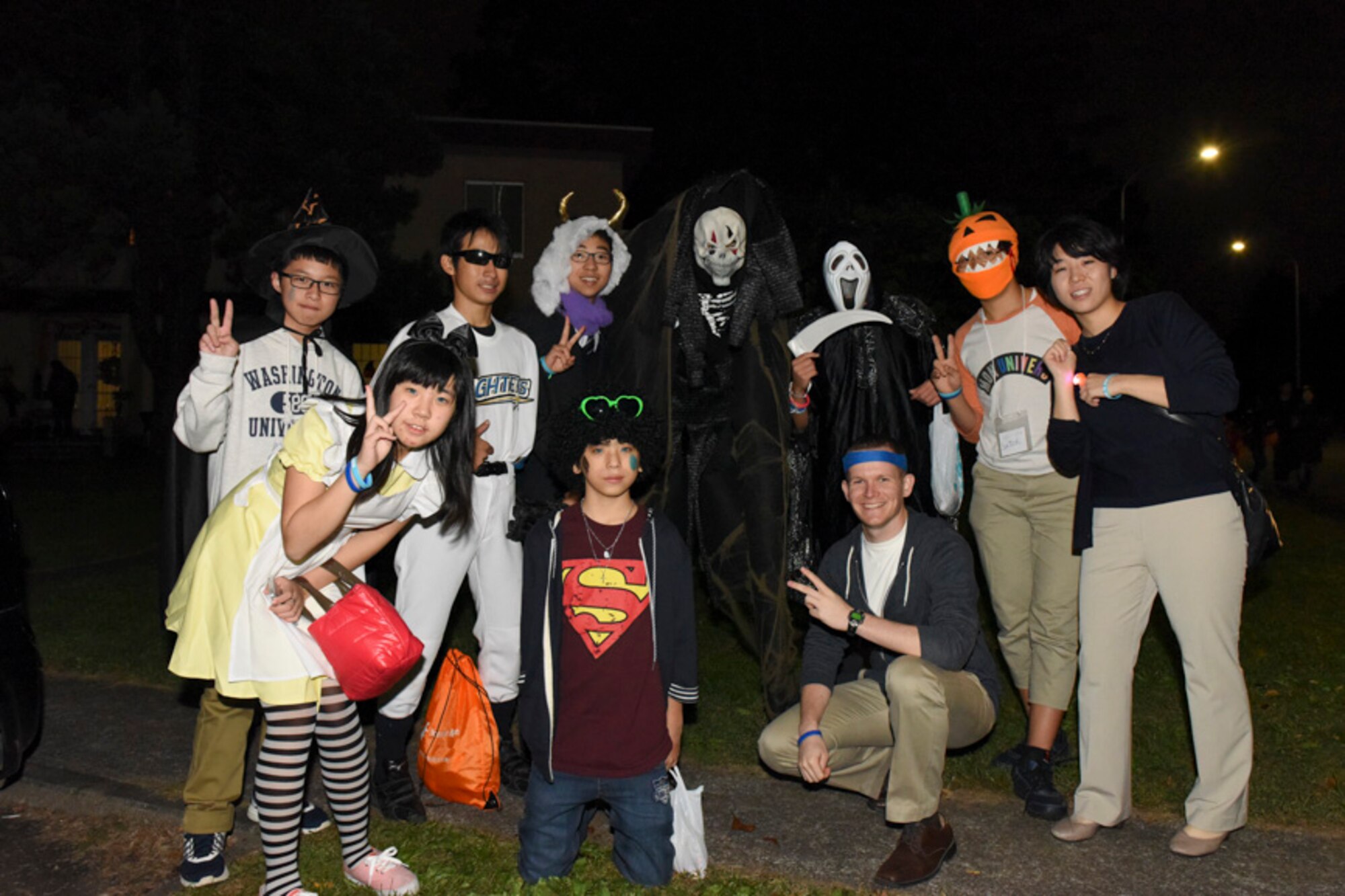 Event attendees pose for a photo during the Youth international Exchange Fair at Yokota Air Base, Japan, Oct. 29, 2016. The fair hosted by the Yokota Company Grade Officers Council and Junior Chamber International Japan to foster interaction between Japanese and Yokota children. Japanese and American student participated in the base-wide trick-or-treat. U.S. Air Force photo by Machiko Arita/Released)