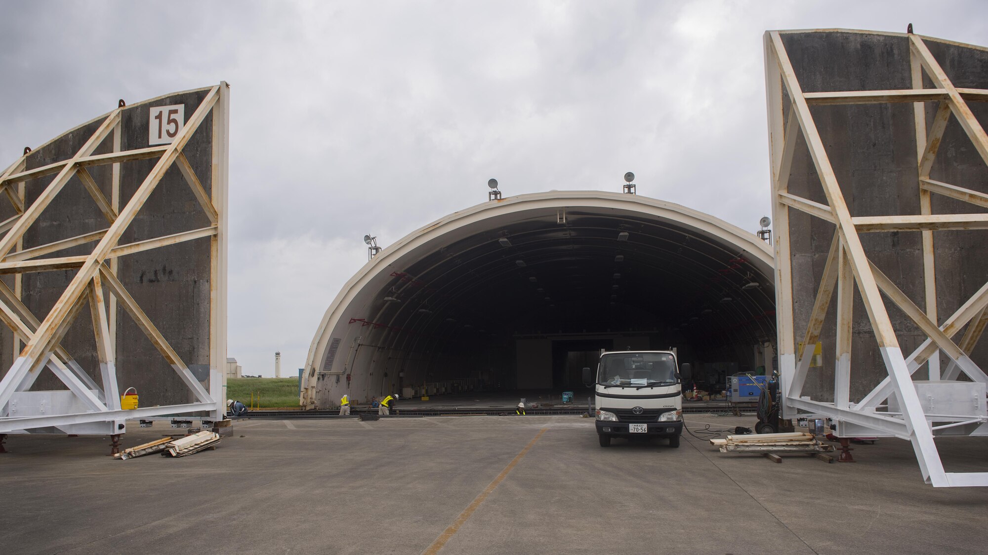 Construction crews work on replacing doors to a hangar Nov. 1, 2016, at Kadena Air Base, Japan. Kadena airfield management oversees all construction and maintenance work done on the airfield to ensure safety and mission readiness. (U.S. Air Force photo by Airman 1st Class Corey M. Pettis/Released)
