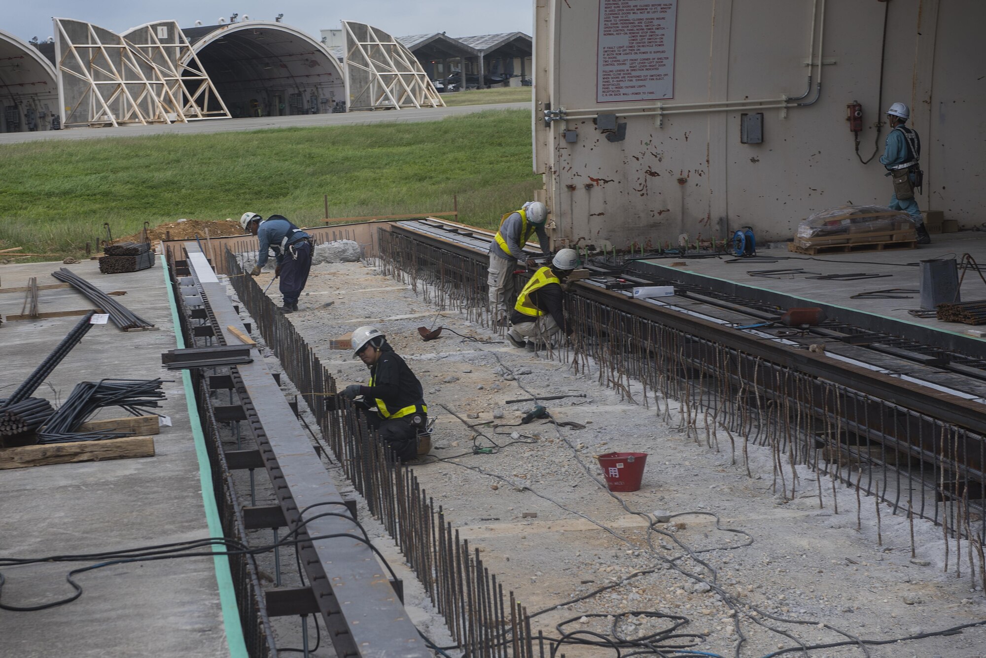 Construction crews work on replacing doors to a hangar Nov. 1, 2016, at Kadena Air Base, Japan. Airfield management oversees and inspects the work being done to ensure it meets quality and safety standards. (U.S. Air Force photo by Airman 1st Class Corey M. Pettis/Released)