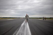 U.S. Air Force Staff Sgt. Ryan Albert, 100th Civil Engineer Squadron power production craftsman measures the distance the Mobile Aircraft Arresting System took to stop an RAF Lakenheath F-15E Strike Eagle Oct. 28, 2016, on RAF Mildenhall, England. The power production shop worked with the 48th Fighter Wing and the 100th Civil Engineering Squadron Fire Department during the MAAS certification process. (U.S. Air Force photo by Senior Airman Christine Halan)