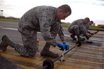 A U.S. Air Force Airmen from the 100th Civil Engineer Squadron power production shop tie down a Mobile Aircraft Arresting System cable Oct. 28, 2016, on RAF Mildenhall, England. The power production shop conducts a certification of the MAAS annually. (U.S. Air Force photo by Senior Airman Christine Halan)