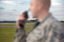 U.S. Air Force Staff Sgt. Ryan Albert, 100th Civil Engineer Squadron power production craftsman, communicates via radio with an F-15E Strike Eagle pilot and the power production shop Oct. 28, 2016, on RAF Mildenhall, England. The power production shop consistently tests the Mobile Aircraft Arresting System, but once a year they conduct re-certification. (U.S. Air Force photo by Senior Airman Christine Halan)