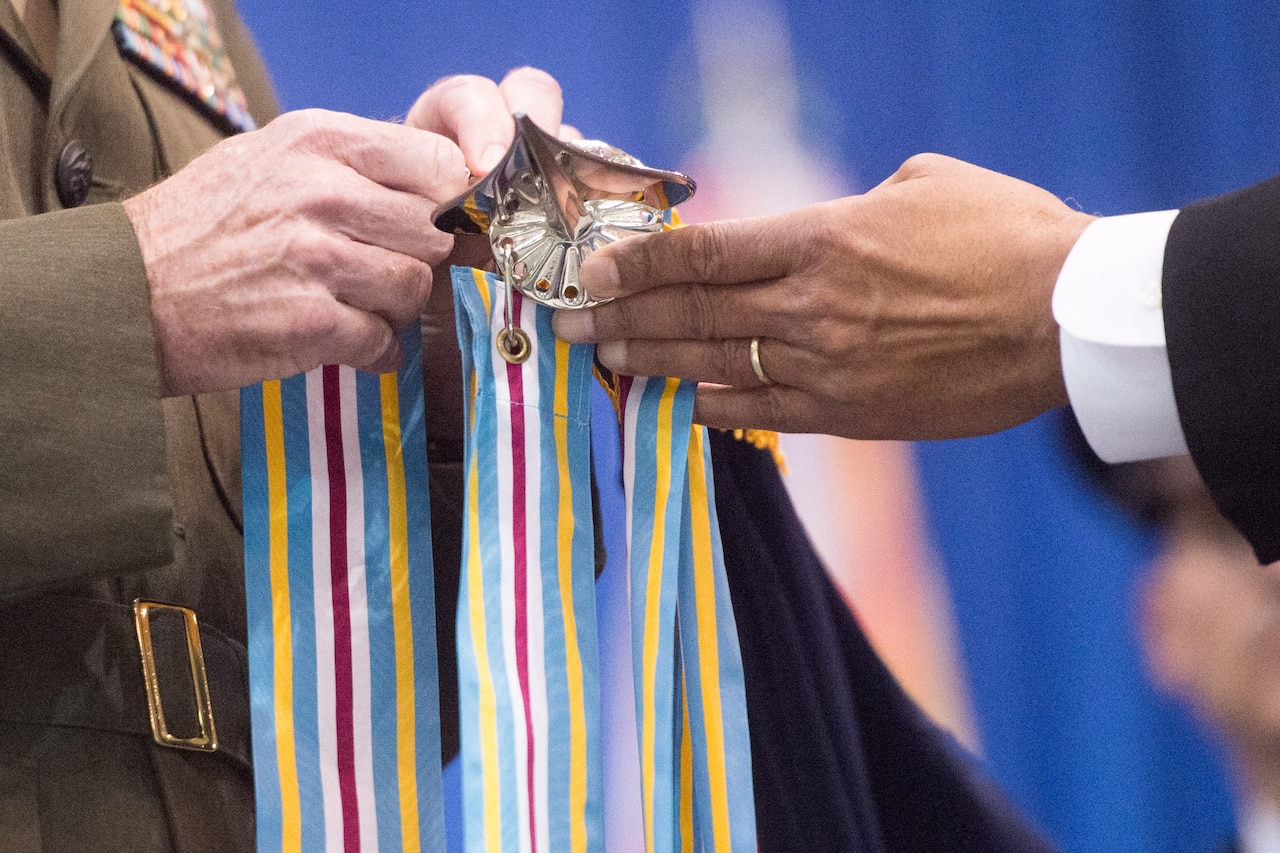 Defense Secretary Ash Carter, right, and Marine Corps Gen. Joe Dunford, chairman of the Joint Chiefs of Staff, attach a Joint Meritorious Unit Award streamer to the Strategic Command organizational flag during the Stratcom change of command ceremony at Offutt Air Force Base, Neb., Nov. 3, 2016. Air Force Gen. John E. Hyten assumed command from Navy Adm. Cecil D. Haney. DoD photo by Navy Petty Officer 2nd Class Dominique A. Pineiro