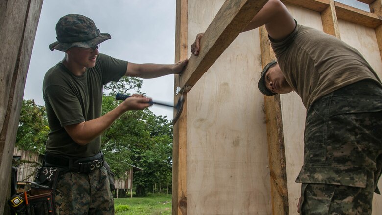 U.S. Marine Cpl. Cody Simons, a native of Scappoose, Oregon, and combat engineer with Special Purpose Marine Air-Ground Task Force - Southern Command, and Honduran Army engineer Darwin Garcia work together to connect the walls of a restroom being built in Leimus, Honduras, Sept. 02, 2016. U.S. Marines and Sailors assigned to Special Purpose Marine Air-Ground Task Force-Southern Command participated in engineering projects, security cooperation and disaster relief preparation in Belize, El Salvador, Guatemala and Honduras. 