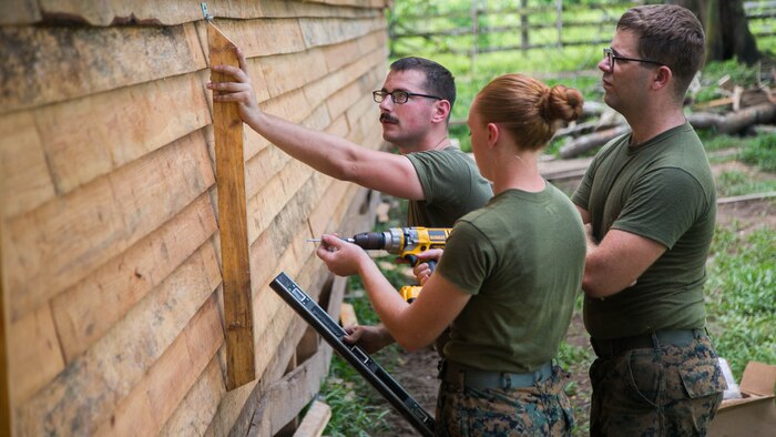 From left, U.S. Marine Sgt. Jordan Vian, a native of Medford, Oregon; Cpl. Sarah Liggett, a native of Hillsboro, Oregon; and Cpl. William Iverson, a native of Eugene, Oregon, all combat engineers with Special Purpose Marine Air-Ground Task Force - Southern Command, align the hinge for the window of a building used to house Honduran soldiers in Leimus, Honduras, Sept. 02, 2016. U.S. Marines and Sailors assigned to Special Purpose Marine Air-Ground Task Force-Southern Command participated in engineering projects, security cooperation and disaster relief preparation in Belize, El Salvador, Guatemala and Honduras. 