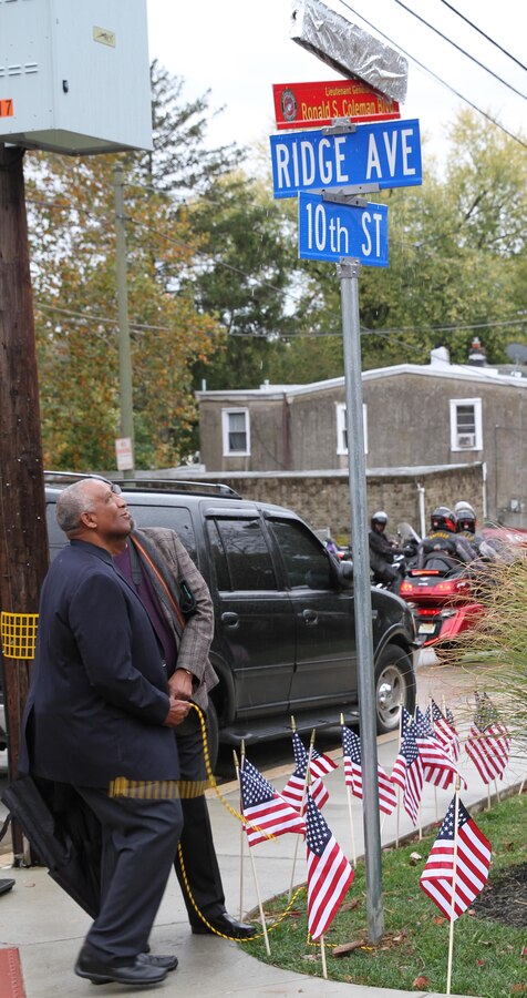 Pet Coleman (left) and Denny Coleman, brothers of the guest of honor, unveil the new street sign to Ronald S. Coleman Boulevard Oct. 22, 2016, in Darby, Pa. Retired U.S. Marine Corps Lt. Gen. Ronald S. Coleman was being honored as a hometown hero during a street dedication ceremony. (U.S. Marine Corps photo by Cpl. Matthew Myers)