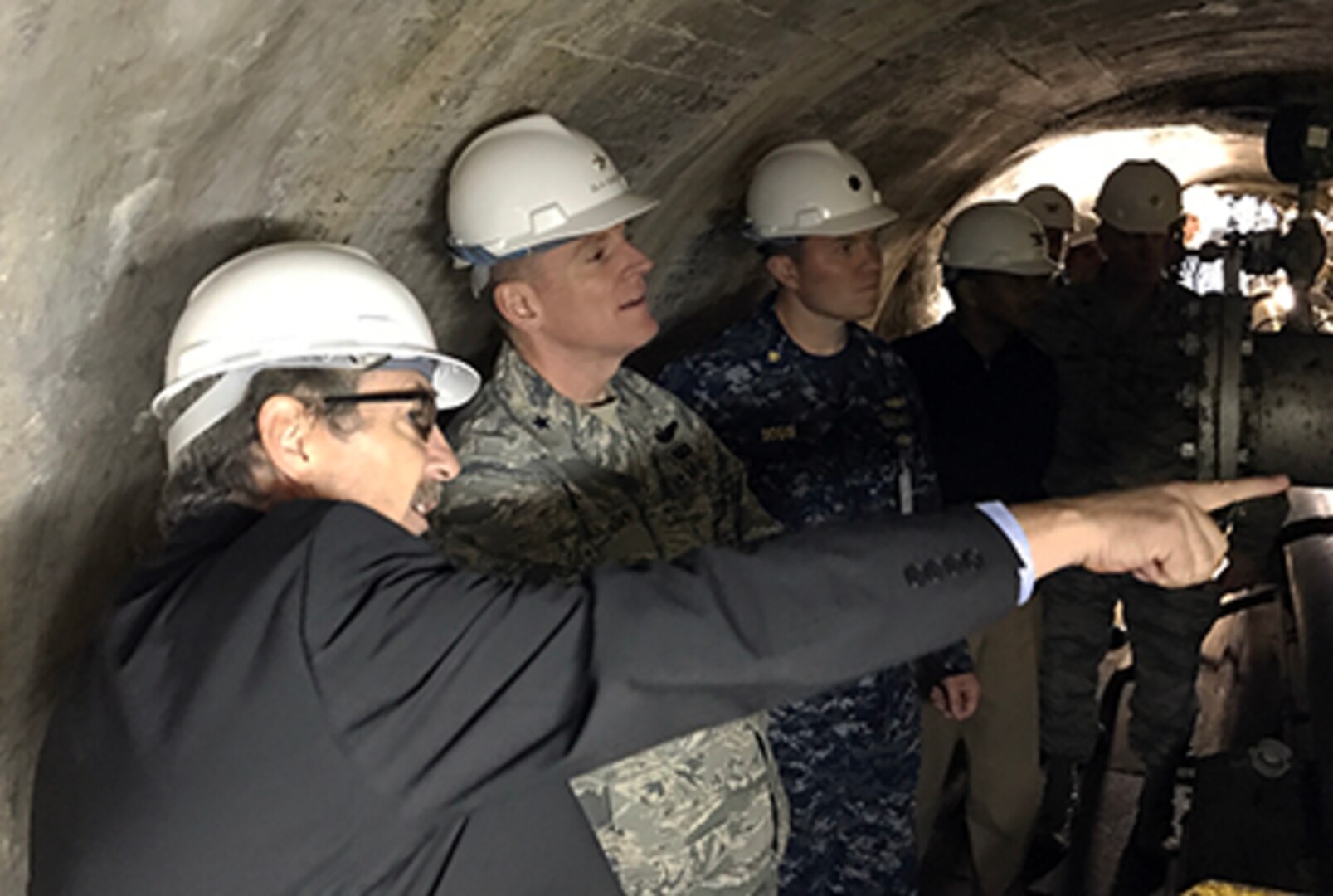 Kanto Plains Fuel Director Steve Shultz, left, explains the unique aspects of the challenging topography and infrastructure onboard Defense Fuel Support Point Hakozaki on the island of Azuma located within Tokyo Bay, Japan, to DLA Energy Commander Air Force Brig. Gen. Martin Chapin, second from left, and other leaders. The underground tunnel at DFSP Hakozaki provides access to valves and piping for a tank originally constructed in 1927.