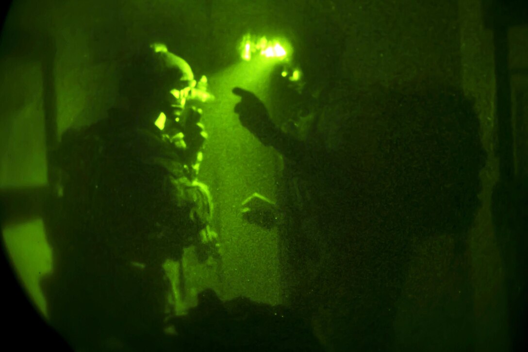 As seen through a night-vision device, Army Special Forces soldiers discus their follow-on objective while participating in a night infiltration and exfiltration exercise during Southern Strike 17 at the Gulfport Combat Readiness Training Center, Miss., Oct. 26, 2016. Air Force photo by Senior Airman Trevor T. McBride