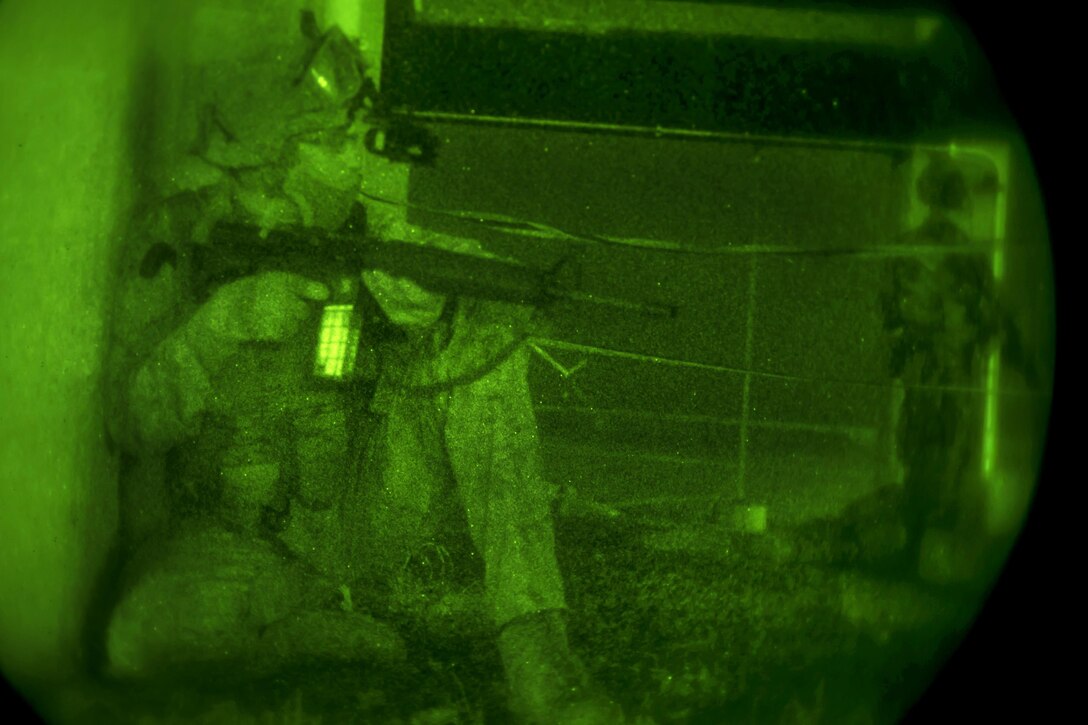 As seen through a night-vision device, an Army Special Forces soldiers provide security during a night infiltration and exfiltration exercise during Southern Strike 17 at the Gulfport Combat Readiness Training Center, Miss., Oct. 26, 2016. Air Force photo by Senior Airman Trevor T. McBride