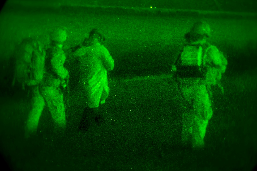 As seen through a night-vision device, an Army Special Forces soldiers escort a role playing detainee during a night infiltration and exfiltration exercise during Southern Strike 17 at the Gulfport Combat Readiness Training Center, Miss., Oct. 26, 2016. Air Force photo by Senior Airman Trevor T. McBride