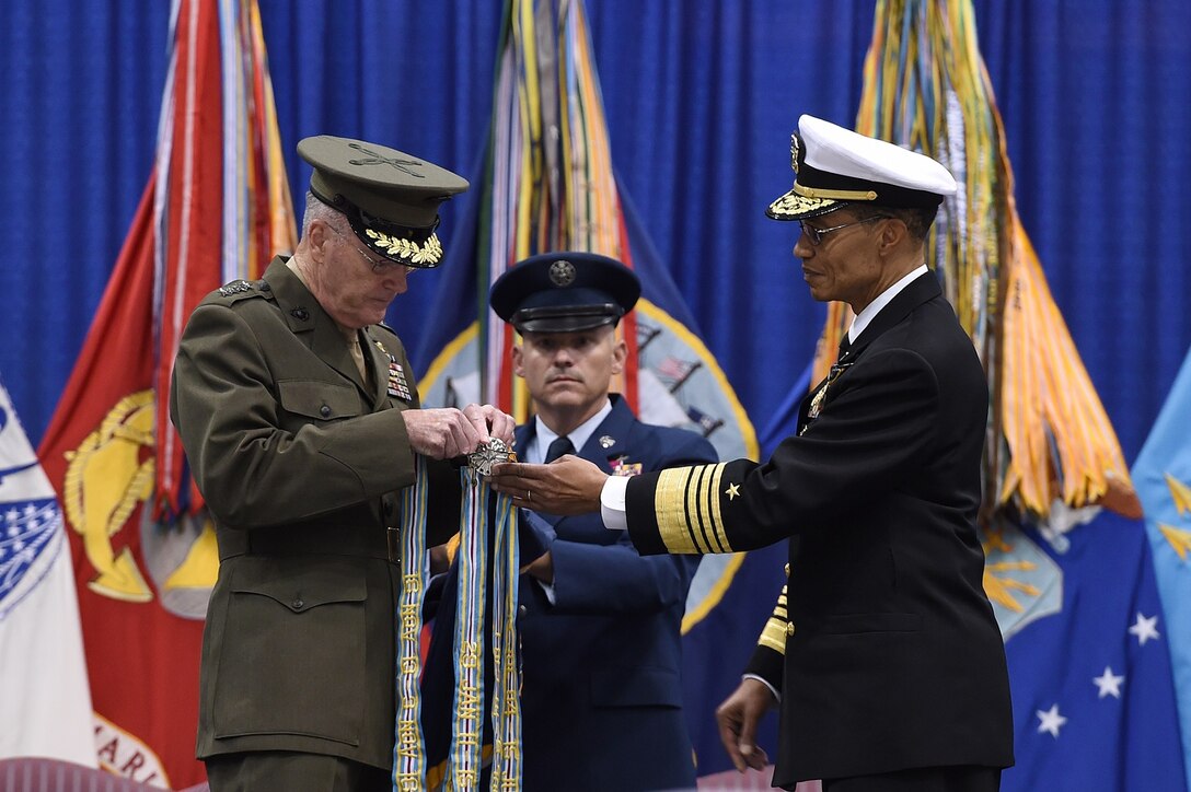 Chairman of the Joint Chiefs of Staff Gen. Joseph F. Dunford (left) attaches the Joint Meritorious Unit Award streamer on the U.S. Strategic Command (USSTRATCOM) guidon during a change of command ceremony at Offutt Air Force Base, Neb., Nov. 3, 2016. The award was presented to USSTRATCOM and its components, who distinguished themselves by exceptionally meritorious service from Nov. 16, 2013, to Nov. 3, 2016. Secretary of Defense Ash Carter presided over the change of command and thanked Adm. Cecil D. Haney (right), outgoing USSTRATCOM commander, for his service. He also congratulated Gen. John E. Hyten on his appointment as the new USSTRATCOM commander. Also pictured is USSTRATCOM Senior Enlisted Leader Chief Master Sgt. Patrick F. McMahon (center). Hyten previously served as commander of Air Force Space Command, and Haney will retire from active military duty during a separate ceremony in January. One of nine DoD unified combatant commands, USSTRATCOM has global strategic missions assigned through the Unified Command Plan that include strategic deterrence; space operations; cyberspace operations; joint electronic warfare; global strike; missile defense; intelligence, surveillance and reconnaissance; combating weapons of mass destruction; and analysis and targeting. (U.S. Air Force photo by Staff Sgt. Jonathan Lovelady)