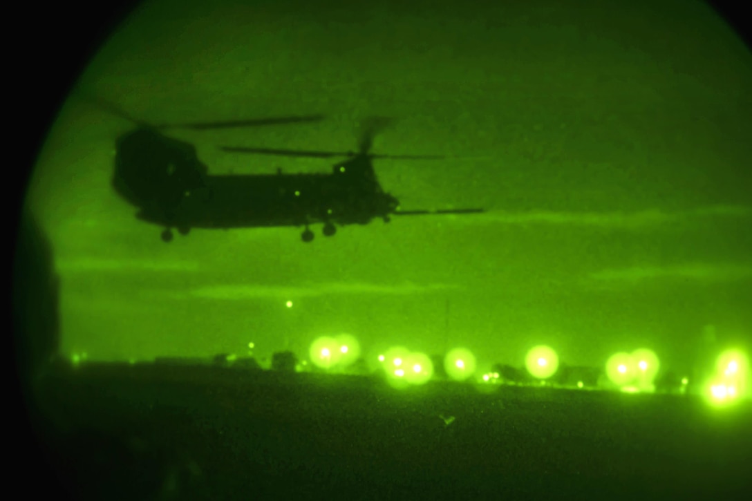 As seen through a night-vision device, an Army MH-47 Chinook helicopter prepares to land as Army Special Forces soldiers participate in a night infiltration and exfiltration exercise during Southern Strike 17 at the Gulfport Combat Readiness Training Center, Miss., Oct. 26, 2016. Air Force photo by Senior Airman Trevor T. McBride