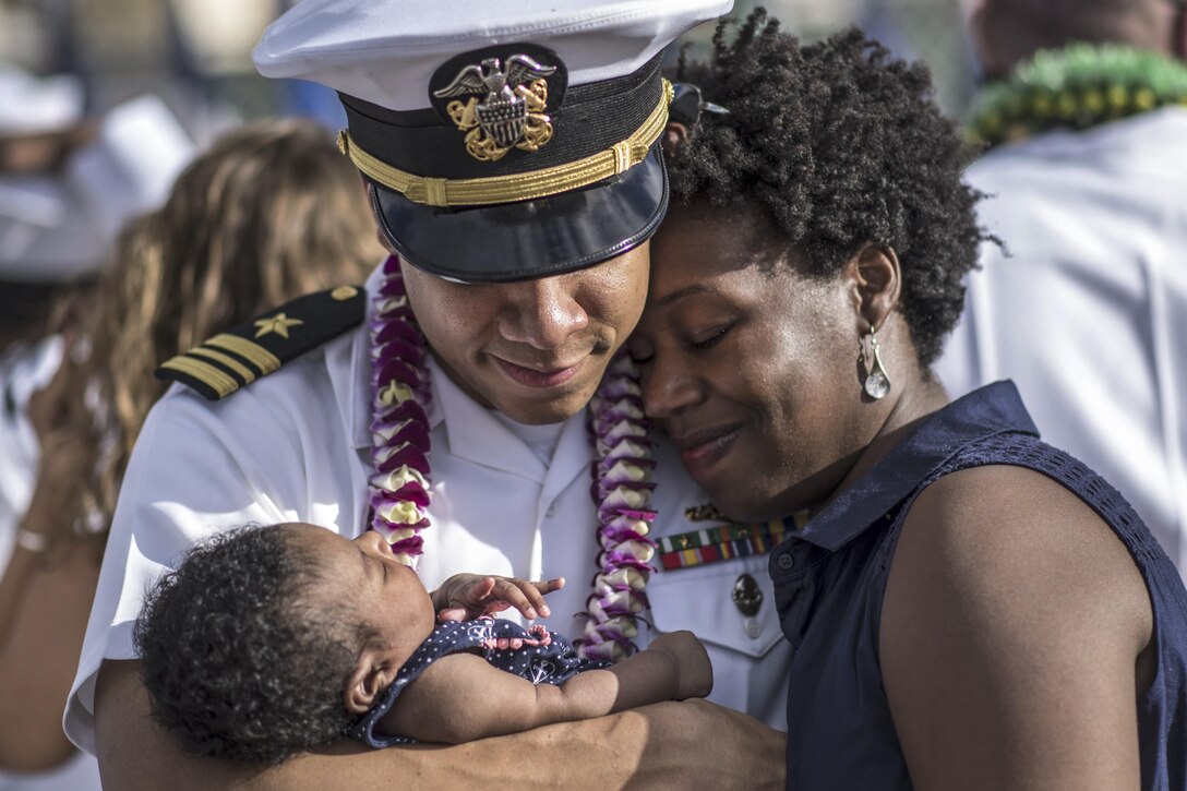Navy Lt. Cmdr. Joseph Edwards embraces his wife and child after completing a six-month deployment to the Western Pacific at Joint Base Pearl Harbor-Hickam, Hawaii, Nov. 3, 2016. Navy photo by Petty Officer 2nd Class Michael H. Lee