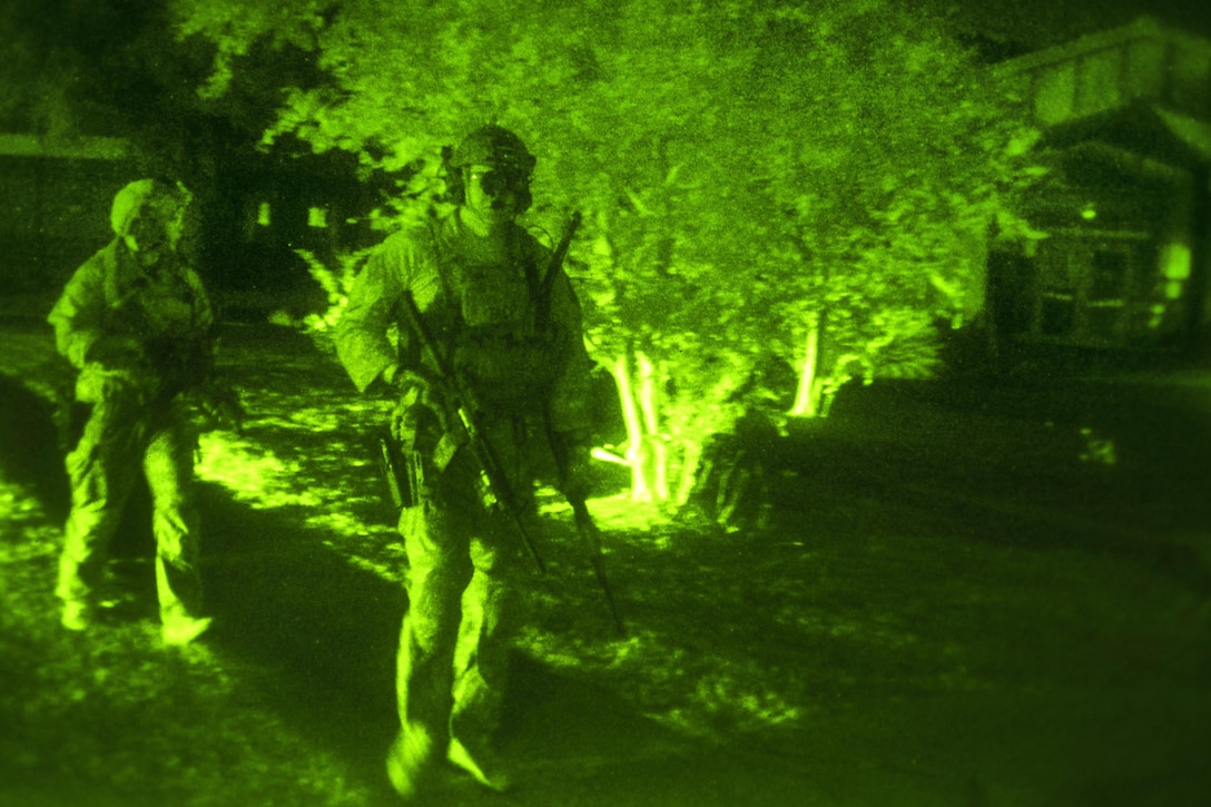 As seen through a night-vision device, Army Special Forces and Air Force special operations forces personnel return to the main body of their team after breaking off to pursue role playing insurgents during a room clearing and close quarters battle operation during Southern Strike 17 at Naval Station Pascagoula, Miss., Oct. 26, 2016. Air Force photo by Tech. Sgt. Gregory Brook