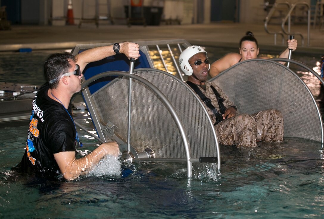 Staff Sgt. Jean Saraka, 3rd Platoon, Company C, Fleet Anti-Terrorism Security Team, Marine Corps Security Force Regiment, simulates a water crash landing during shallow water egress training at the Aviation Survival Training Center, aboard Naval Station Norfolk, 1 Nov. The Marines from Company C completed SWET as part of predeployment training to ensure they are capable of exiting a helicopter properly in the event of an emergency. (Official U.S. Marine Corps photo by Sgt. Calvin Shamoon/ Released) 