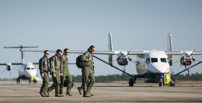 An aircrew walks by a C-145A Skytruck and C-146 Wolfhound on their way to their aircraft for a mission at Duke Field, Fla.  The 919th Special Operations Wing is the only wing in the Air Force that flies and maintains the Skytruck.  They are primarily used for new aircrew qualifications and flight proficiency missions.  (U.S. Air Force photo/Tech. Sgt. Sam King)  