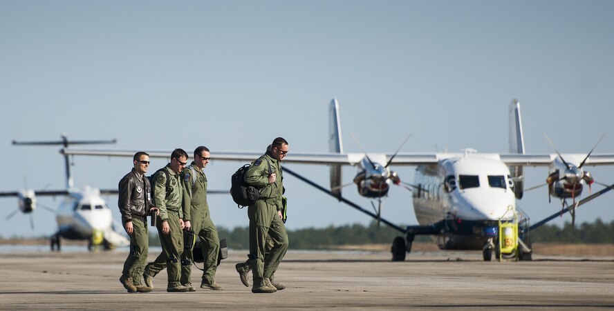 An aircrew walks by a C-145A Skytruck and C-146 Wolfhound on their way to their aircraft for a mission at Duke Field, Fla.  The 919th Special Operations Wing is the only wing in the Air Force that flies and maintains the Skytruck.  They are primarily used for new aircrew qualifications and flight proficiency missions.  (U.S. Air Force photo/Tech. Sgt. Sam King)  